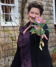 woman smiling and holding a flower finding the one online