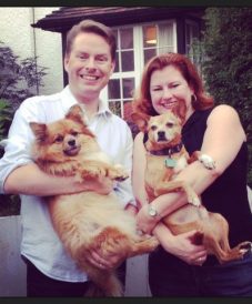 happy couple holding their 2 dogs