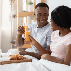 Love U success story of happy couple wearing all white having breakfast in bed