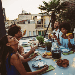 Group of friends and lovers sitting around the table eating, talking and laughing