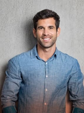 attractive man smiling wearing a blue long sleeve