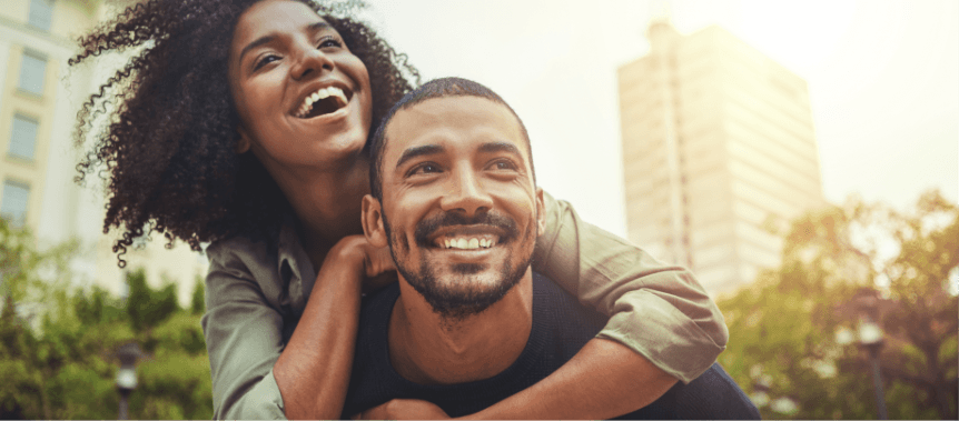 handsome man giving her pretty woman piggyback ride - love u success story