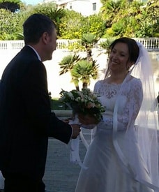 Love U success story of newly married couple laughing together while holding a wedding bouquet