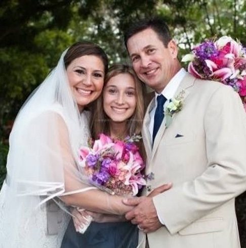 Love U successful love story of cheerful married couple smiling to the camera with their daughter